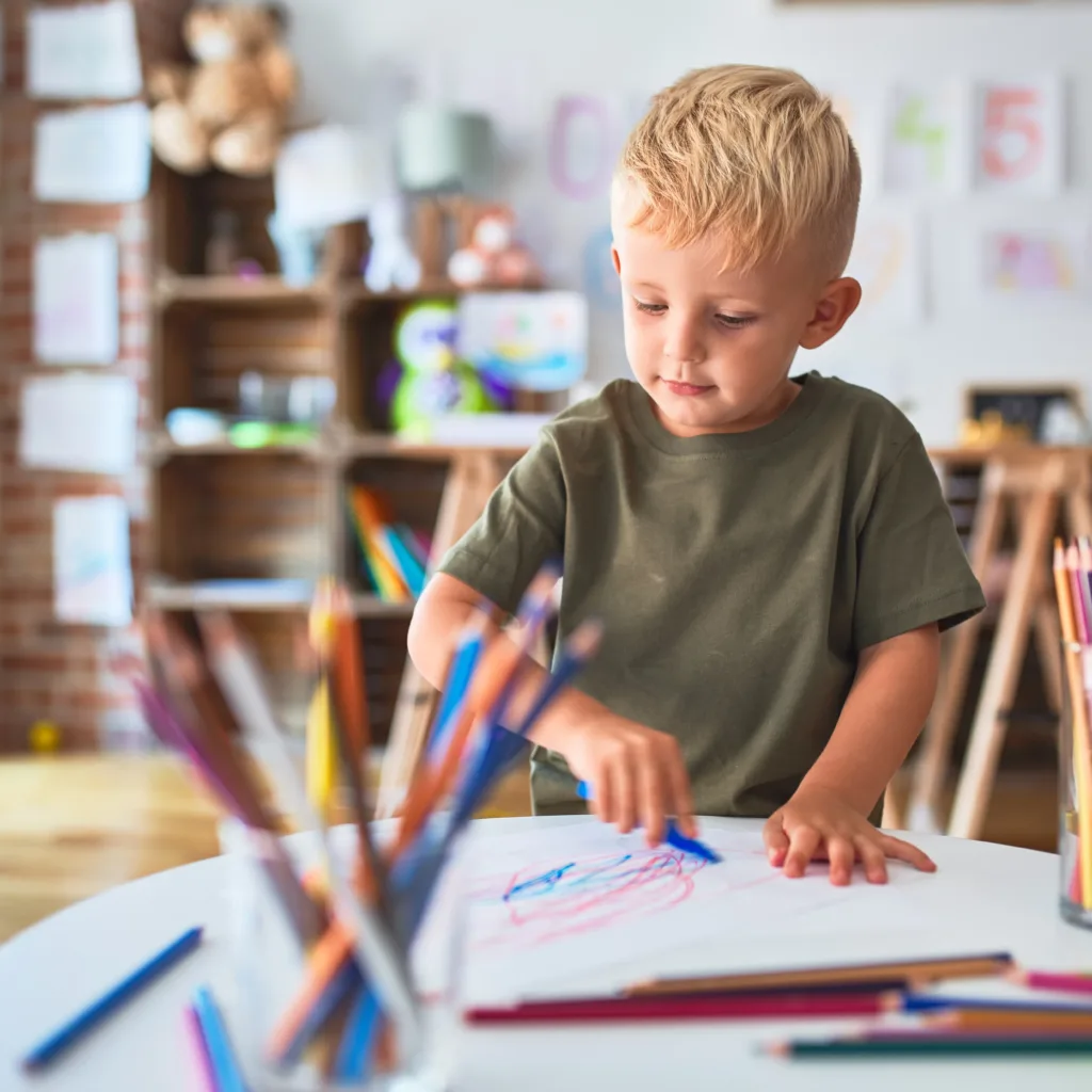 Un enfant qui dessine dans une salle de jeux.